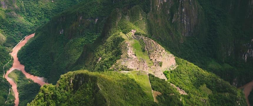 Aerial view of a stone citadel on a green mountain
